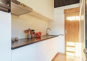 a kitchen with white cabinets and a counter top at Tiny House nabij Brugge in Beernem