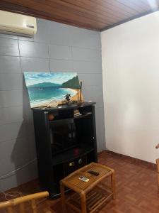 ein Gemälde auf einem Stand in einem Zimmer mit einem Tisch in der Unterkunft Elitineide Guest House in São Tomé