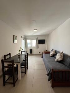 ein Wohnzimmer mit einem Bett und einem Esstisch in der Unterkunft DEPARTAMENTO 20 DE FEBRERO in Salta