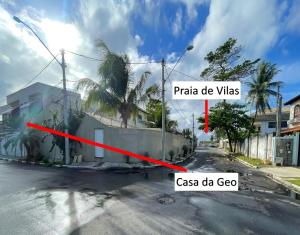 a house on the side of a street with a red arrow at Casa Moderna com 2 Suites e Home Office na Praia in Lauro de Freitas