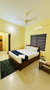 1 dormitorio con 1 cama grande y 1 mesa en Mystique Inn Wayanad en Vythiri