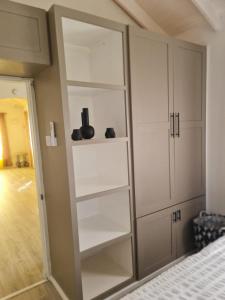 a closet with white cabinets and shoes on the shelves at Green Door Oasis in Christ Church