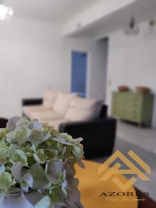 a vase of flowers sitting on a table in a living room at Azores village apartments in Fontinhas