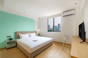 1 dormitorio con 1 cama blanca y TV en LNCommunity Guangzhou Haizhu Branch, en Guangzhou