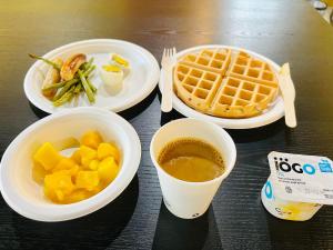 uma mesa com pratos de comida e um waffle e café em Fullerton Manor Inn em Cataratas do Niágara