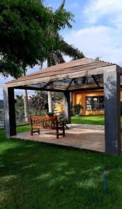 un pavillon avec banc dans un parc dans l'établissement Alto Da Serra Villas, à Bananeiras