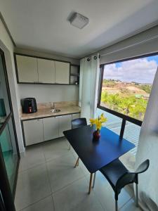 une cuisine avec une table et des chaises ainsi qu'une fenêtre dans l'établissement Alto Da Serra Villas, à Bananeiras