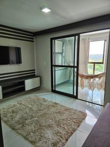 a living room with a television and a rug at Alto Da Serra Villas in Bananeiras