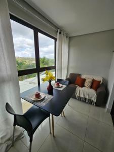 a living room with a table and a couch at Alto Da Serra Villas in Bananeiras