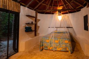 ein Schlafzimmer mit einem Bett in einem Zimmer mit einem Fenster in der Unterkunft Villa Maya - Glamping - Natural Reserve in Cozumel