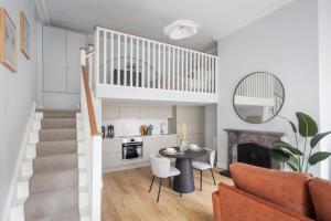 a living room with a staircase and a table and chairs at Urban Rest Merrion Square Apartments in Dublin