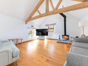 ein Wohnzimmer mit einem Sofa und einem Kamin in der Unterkunft Swallow Barn in Cockermouth