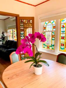 a table with a potted plant on it with stained glass at Handcrafted stained-glass cottage, free parking in Hobart