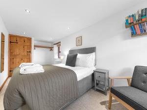 a bedroom with a bed and a chair at Swallow Barn in Cockermouth