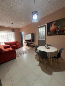 a living room with a table and a red couch at DEPARTAMENTO PASEOS DE XCACEL in Playa del Carmen