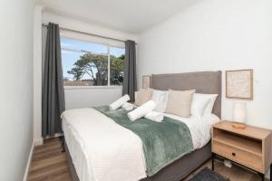 sypialnia z dużym łóżkiem i oknem w obiekcie Claremont Apartment With Three Bedrooms w Kapsztadzie