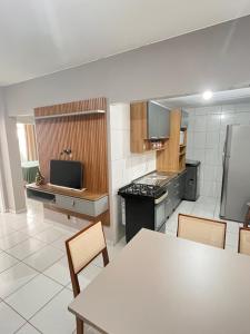a large kitchen with a table and chairs in it at Apartamento Av. atlântica lateral BrisamarBC6 in Balneário Camboriú