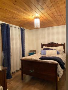 a bedroom with a bed with a wooden ceiling at Ferme Jardin Potager in Sainte-Rose-du-Nord