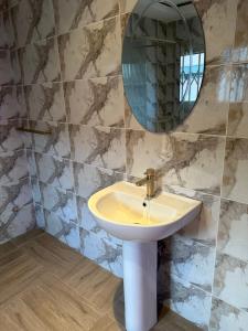 La salle de bains est pourvue d'un lavabo et d'un miroir. dans l'établissement D Barfi Guesthouse, excellent location, à Kumasi