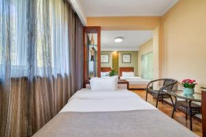 杭州市にあるハンジョウ ボーカイ ウェストレイク ホテルのベッド2台とテーブルが備わるホテルルームです。