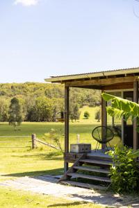 une terrasse couverte d'une maison avec un champ en arrière-plan dans l'établissement THE MAINSTAY FARMSTAY Unique Aussie Farmstay, Seal Rocks, Barrington Coast, à Neranie
