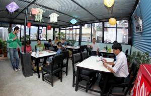 un gruppo di persone sedute ai tavoli di un ristorante di Bag Packer's Lodge a Kathmandu