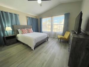 1 dormitorio con 1 cama y TV de pantalla plana en Pool House Newly Remodeled 3bed 3bath Near DT Summerlin and Red Rock, en Las Vegas