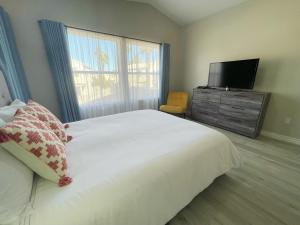 a bedroom with a large bed and a flat screen tv at Pool House Newly Remodeled 3bed 3bath Near DT Summerlin and Red Rock in Las Vegas