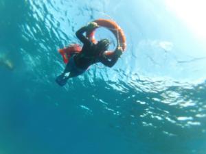 een persoon die in het water zwemt met een reddingsvest bij Pez Espada Tours y Cabinas in Drake