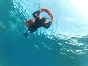 a person swimming in the water with a life preserver at Pez Espada in Drake