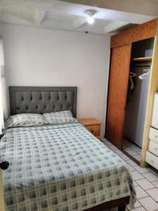 ein Schlafzimmer mit einem Bett in einem Zimmer mit einem Schrank in der Unterkunft Casa Lili in Cuernavaca