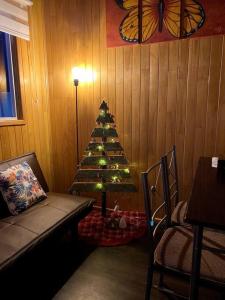 Un árbol de Navidad en una esquina de una habitación en Cabaña Cardinal, en Puerto Varas