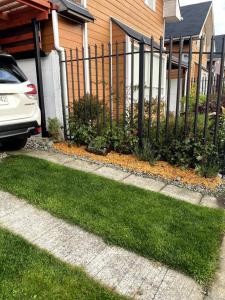 una cerca en un patio al lado de una casa en Cabaña Cardinal, en Puerto Varas