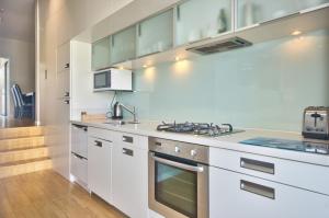 Pure Retreat Lake View في كوينزتاون: مطبخ بخزائن بيضاء وفرن موقد +15 صورة