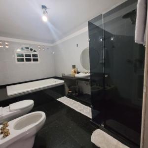 uma casa de banho com um chuveiro, um WC e um lavatório. em Cantinho do SOSSEGO, a 2 km da praia de Itapuã, no centro da cidade, wifi, ideal para CASAL em Vila Velha