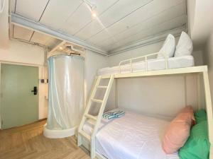 Etagenbett in einem kleinen Zimmer mit einer Leiter in der Unterkunft The Greens Old Town Bangkok in Bangkok