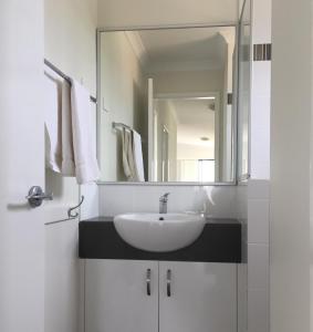 een badkamer met een wastafel en een spiegel bij Dongara Tourist Park in Port Denison