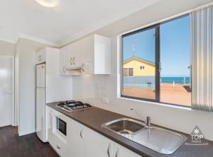 a kitchen with a sink and a view of the ocean at Dongara Tourist Park in Port Denison