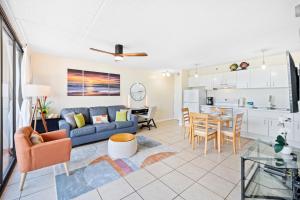 a living room with a blue couch and a kitchen at Cozy Waikiki Getaway, Stroll to Beach with Free Parking in Honolulu