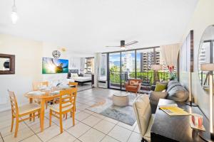a living room with a table and a couch at Cozy Waikiki Getaway, Stroll to Beach with Free Parking in Honolulu