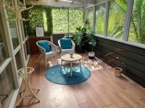 a screened in porch with two chairs and a table at Simply Sassafras - Hydrangea Suite - self-contained in Sassafras