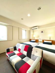 青森的住宿－Aomori Green Park Hotel，一间带两张床和一张沙发的卧室