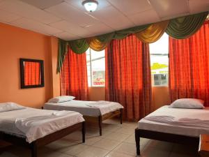 a room with three beds and a window at CASA DE HOSPEDAJE PEDERNALES in Pedernales