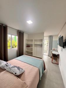 a bedroom with a bed and a window and a desk at Los Hermanos Residencial in Florianópolis