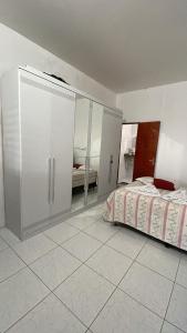 アラカティにあるACONCHEGO Guest Houseの白いキャビネットとベッドが備わるベッドルーム1室