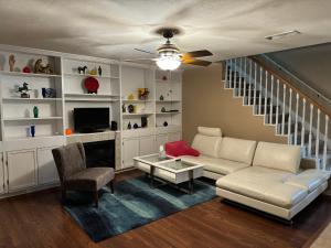 a living room with a white couch and a tv at A stylish and Comfy Place to Stay in Gainesville