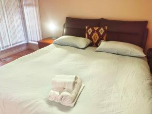 Una cama blanca con dos toallas. en Lovely suite, en Surrey