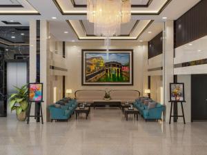 a lobby with a table and chairs and a painting at ViAn Hotel And Spa Danang in Da Nang