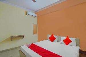 Un dormitorio con una cama con almohadas rojas. en OYO Flagship Mohan Residency, en Indirapuram