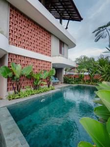 a swimming pool in front of a house at Tarate Loft Studio Ubud in Ubud